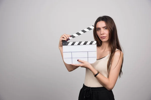 Young Brunette Woman Clapperboard Standing Gray Background High Quality Photo — Stock Photo, Image