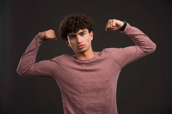 Modelo Joven Con Pelos Rizados Mostrando Sus Músculos Foto Alta —  Fotos de Stock