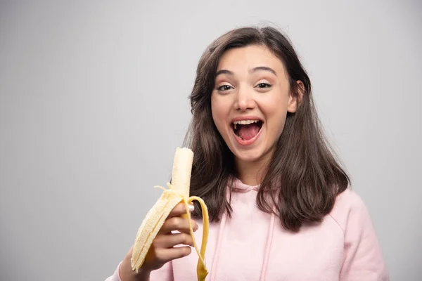 Jeune Femme Mangeant Banane Sur Fond Gris Photo Haute Qualité — Photo