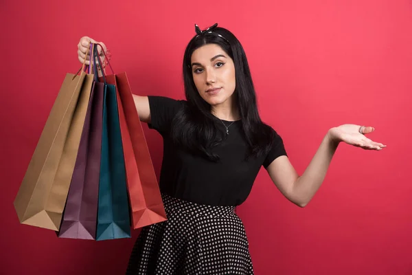 Vrouw Tonen Haar Tassen Rode Achtergrond — Stockfoto