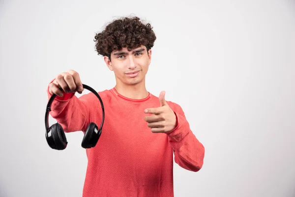 ヘッドフォンを持って親指を放棄する若い男 高品質の写真 — ストック写真