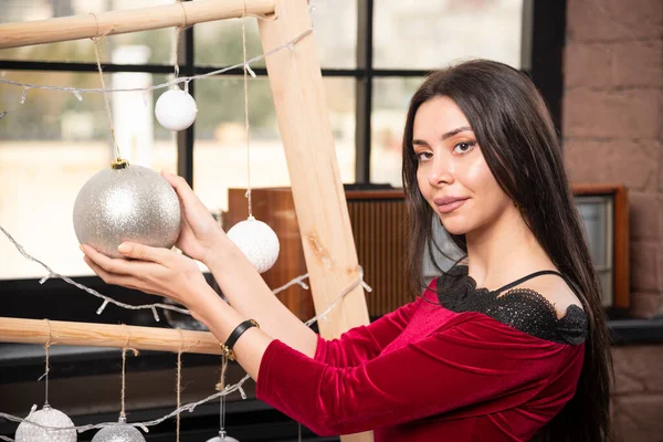 Фото Молодой Брюнетки Модели Красном Платье Серебряным Рождественским Мячом Высокое — стоковое фото