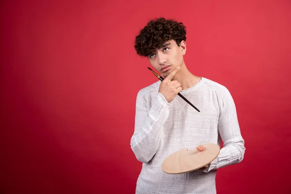 Jeune Artiste Masculin Posant Avec Palette Pinceau Sur Fond Rouge — Photo
