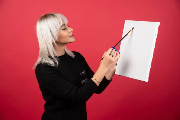 Junge Künstlerin Zeichnet Auf Leinwand Auf Rotem Hintergrund Hochwertiges Foto — Stockfoto