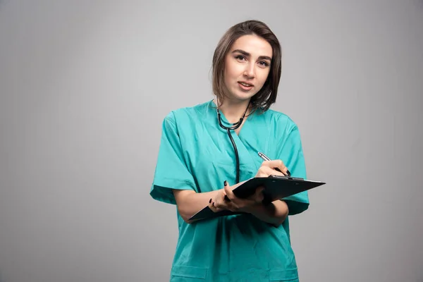 Joven Médico Uniforme Azul Pie Sobre Fondo Gris Foto Alta — Foto de Stock