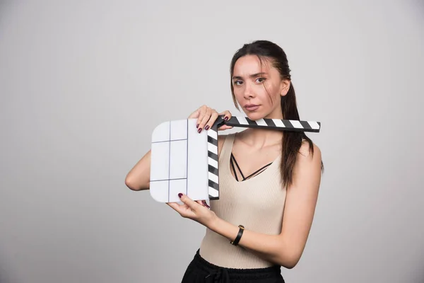 Brunett Kvinna Poserar Med Clapperboard Grå Bakgrund Högkvalitativt Foto — Stockfoto