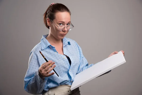 Frau Mit Leerer Leinwand Und Pinsel Auf Grauem Hintergrund — Stockfoto