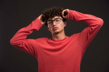 Saçları kıvırcık genç bir manken kafasına dokunuyor. Yüksek kalite fotoğraf