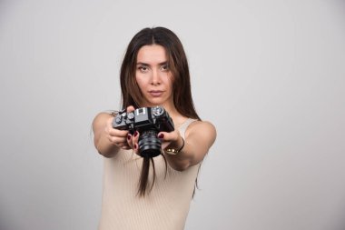 Gri arka planda kamera veren güzel bir kadın. Yüksek kalite fotoğraf