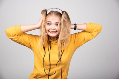 Kulaklıklı genç bir kadın mutlu bir şekilde gülümsüyor. Yüksek kalite fotoğraf