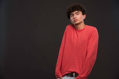 Kıvırcık saçlı genç manken elini cebine atıyor. Yüksek kalite fotoğraf