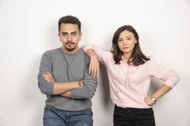 Ciddi bir ifadeyle ayakta duran genç bir çift. Yüksek kalite fotoğraf