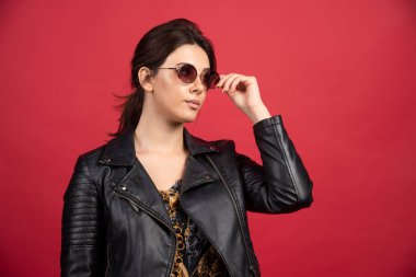 Siyah güneş gözlüğü takan siyah deri ceketli havalı kız. Yüksek kalite fotoğraf