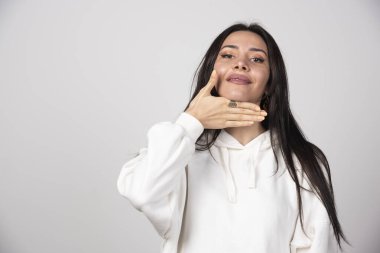 Beyaz kapüşonlu genç bir kadın modelin çene altından el ele tutuşması. Yüksek kalite fotoğraf