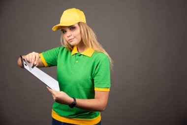 Kalem ve not panosu olan genç bir kadın kurye. Yüksek kalite fotoğraf