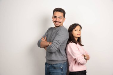 Beyaz arka planda kollarını kavuşturmuş genç bir çift. Yüksek kalite fotoğraf