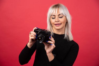 Kırmızı arka planda kameraya bakan genç bir kadın. Yüksek kalite fotoğraf