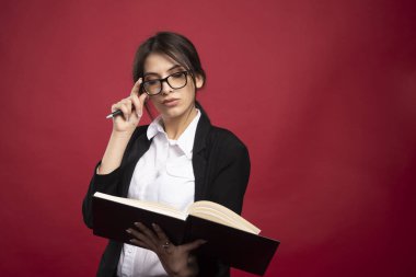 Gözlüklü genç bir çalışan kitap tutuyor. Yüksek kalite fotoğraf