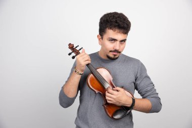 Kahverengi ahşap kemanını çalan bir müzisyen. Yüksek kalite fotoğraf