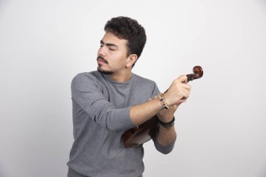 Müzisyen kemanın melodisini kontrol ediyor ve tamir ediyor. Yüksek kalite fotoğraf