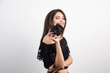 Beyaz arka planda kamera tutan güzel bir kadın. Yüksek kalite fotoğraf