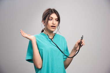 Kadın doktorun portresi gri arka plandaki sonuçlara şaşırdı. Yüksek kalite fotoğraf