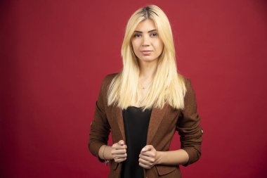 Kırmızı arka planda duran sıradan kıyafetli bir ofis çalışanı. Yüksek kalite fotoğraf