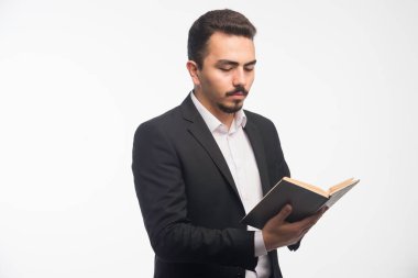 Siyah takım elbiseli bir iş adamı görev listesini tutuyor ve kontrol ediyor. Yüksek kalite fotoğraf