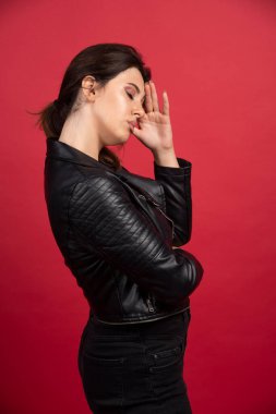 Siyah deri ceketli havalı kız baştan çıkarıcı pozlar veriyor. Yüksek kalite fotoğraf
