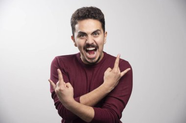 Ciddi bir esmer adam ayakta ve yüksek kalite fotoğraf çekiyor.