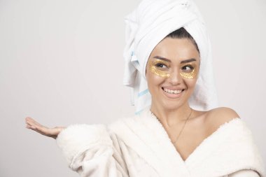 Bornoz ve kozmetik göz bantları takan genç bir kadın. Yüksek kalite fotoğraf