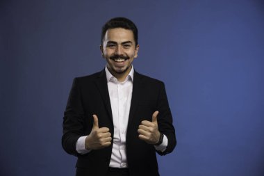 Siyah takım elbiseli bir işadamı başparmak işareti yapar. Yüksek kalite fotoğraf