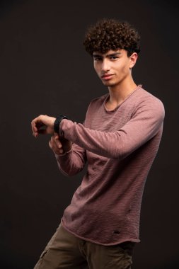 Gayri resmi kış kıyafetleri içinde saatlerini tanıtan genç bir manken. Yüksek kalite fotoğraf