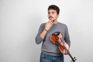 Kemanını tutan müzisyen çalacağı bir sonraki parçayı düşünüyor. Yüksek kalite fotoğraf