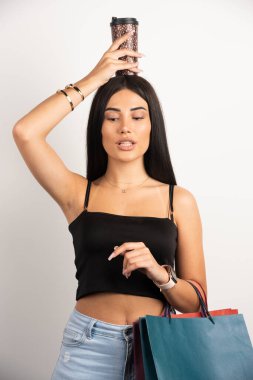 Kafasının üstünde bir fincan kahve tutan kadının portresi. Yüksek kalite fotoğraf