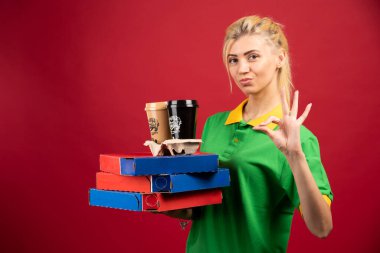 Siparişleri taşıyan teslimatçı kadın ve tamam işareti yapıyor. Yüksek kalite fotoğraf