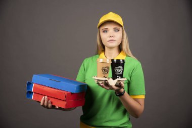 Elinde kahve ve karton pizza tutan teslimatçı kadın. Yüksek kalite fotoğraf
