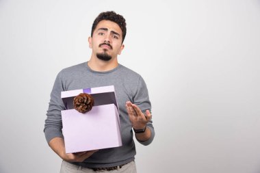 Elinde kozalaklı mor bir kutu tutan genç bir adam. Yüksek kalite fotoğraf