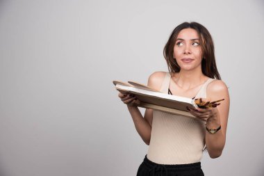 Gri arka planda resim aletleriyle poz veren genç bir sanatçı. Yüksek kalite fotoğraf