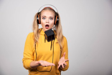 Kulaklıklı güzel bir kadın saatle oynuyor. Yüksek kalite fotoğraf