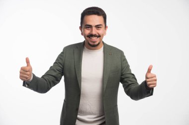 Kıyafet yönetmeliğindeki bir işadamı parmak kaldırır. Yüksek kalite fotoğraf