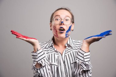 Gri arka planda yüzü boyalı poz veren kadın. Yüksek kalite fotoğraf