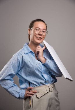 Boş tuval ve gri arka planda fırça kullanan kadın 