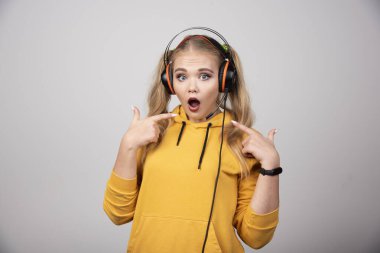Kulaklıklı sarışın kadın kendini işaret ediyor. Yüksek kalite fotoğraf