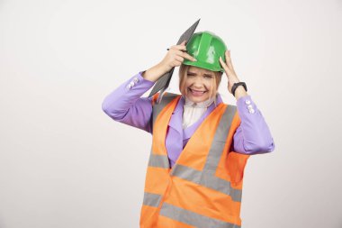 Beyaz arka planda yeşil miğferi ve panosu olan genç bir kadın müteahhit. Yüksek kalite fotoğraf