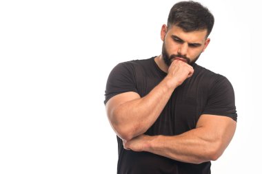 Siyah gömlekli sporcu yumruklarını gösteriyor ve düşünce pozisyonunu alıyor. Yüksek kalite fotoğraf