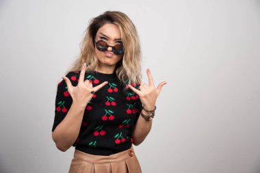 Sarışın kadın gözlüklü poz veriyor ve ellerini gösteriyor. Yüksek kalite fotoğraf