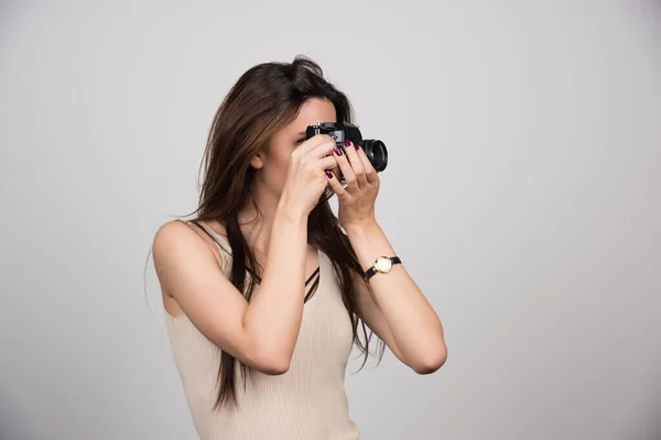 Mladá Žena Fotí Kamerou Šedém Pozadí Kvalitní Fotografie — Stock fotografie