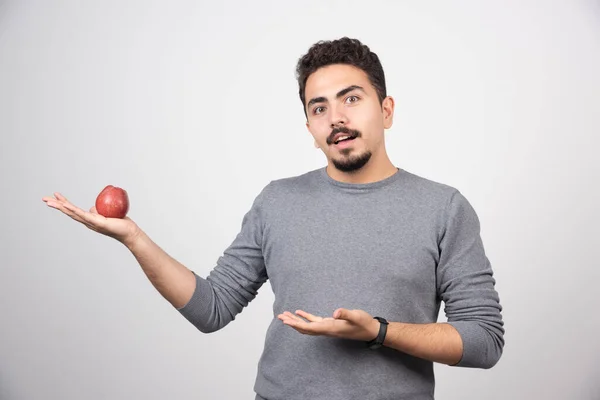 Brünetter Mann Mit Rotem Apfel Blickt Die Kamera Hochwertiges Foto — Stockfoto