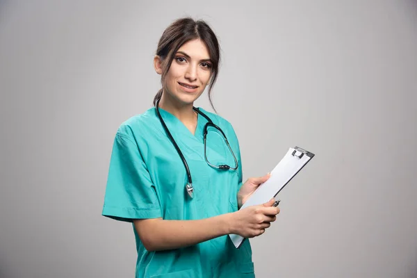 Doctora Sosteniendo Portapapeles Sobre Fondo Gris Foto Alta Calidad — Foto de Stock